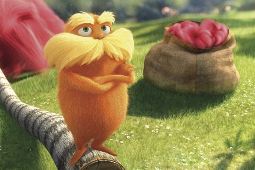 Orange furry cartoon with a big bushy yellow mustache and big bushy yellow eyebrows (The Lorax) crossing his arms while standing on a tree that has been cut down. 