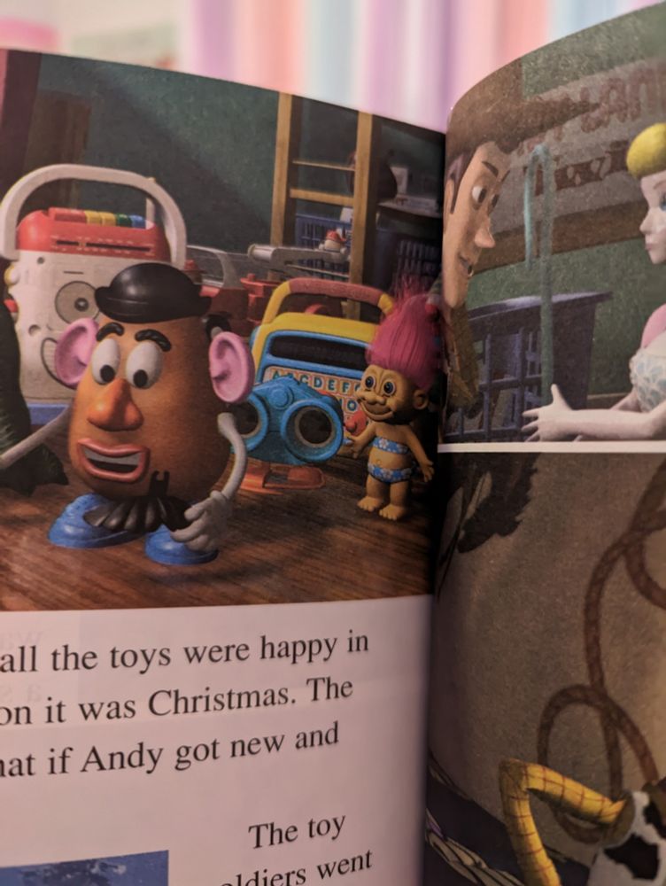 A picture of a child's book version of Toy Story that features a Trolls toy