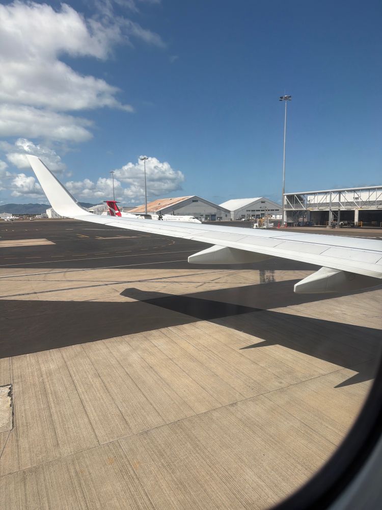 Looking out one of the rear windows of a 737 towards the trailing edge of the left wing. Winglet in the distance. 